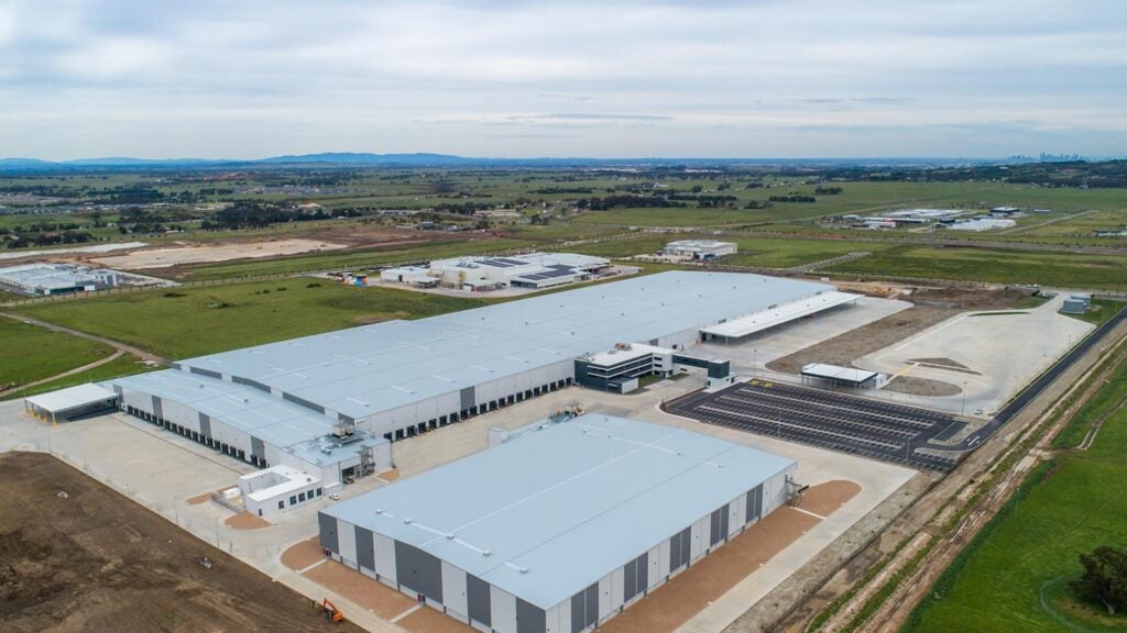 A wide aerial shot of a large industrial complex featuring several grey metal warehouses