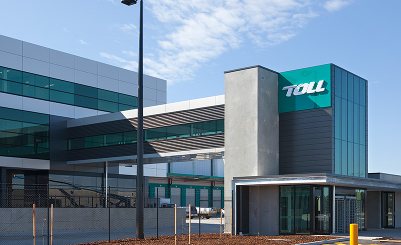 Exterior view of a multi-storey TOLL facility featuring a skybridge connecting two modern buildings